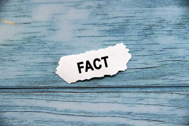 istock fact wording  or text on small piece of hard white plastic with blue background.Copy space and business concept. 2163015286