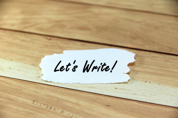 istock let's write! Short word english letter or text on white paper with brown background.Copy space concept and selection focus. 2163016885