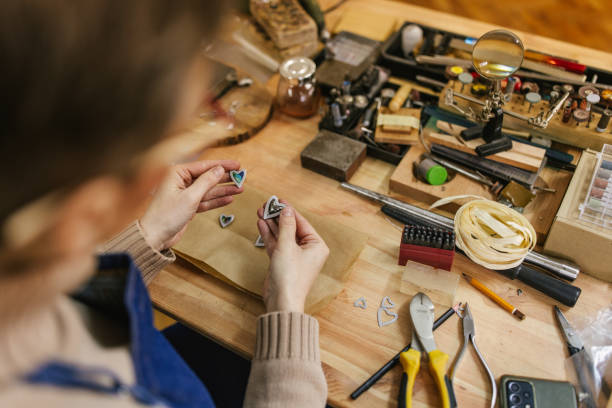 istock Person crafting jewelry with tools at a busy workbench. 2163018046