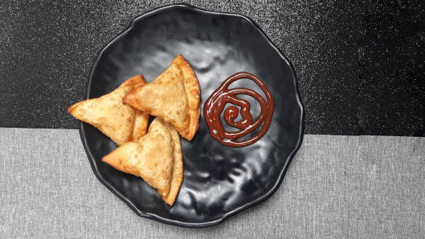 istock Fried pastries on top of a black plate 2163018114