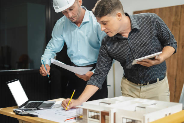 istock Architect caucasian man working, blueprint meeting for project working with partner on model building at company office. 2163019135