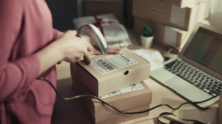 Warehouse Worker Checks and Seales Cardboard Box Ready for Shipment