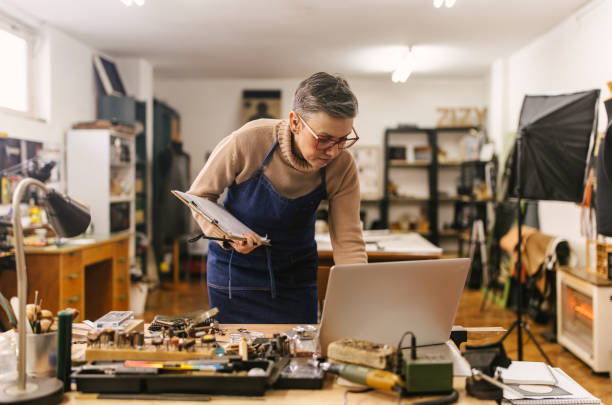 istock Jeweller working on laptop in creative workshop setting 2163019221