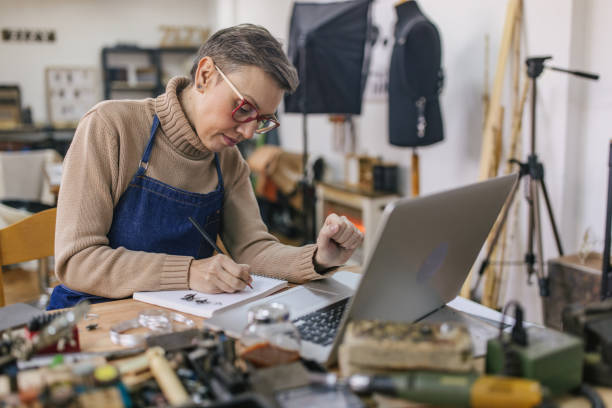 istock Jeweller sketching at a table with tools in workshop 2163019831