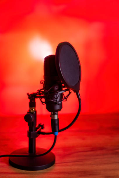 istock Black professional microphone on a stand. Pop filter installed on the microphone. A red toned picture. 2163020860