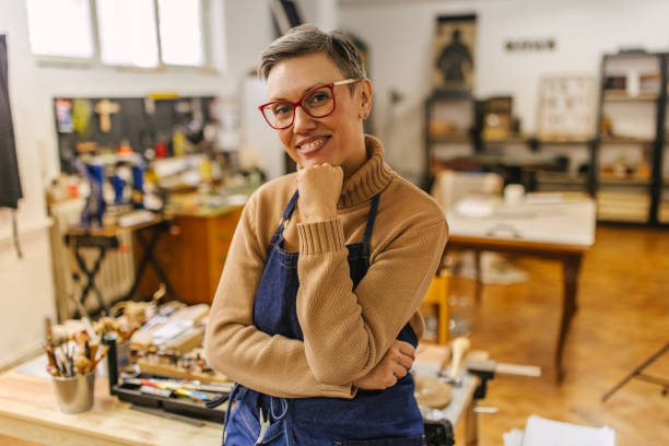 istock Jeweller in a studio, hand on face, surrounded by tools. 2163021341