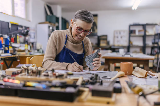 istock Jeweller documenting earnings at busy worktable 2163021769