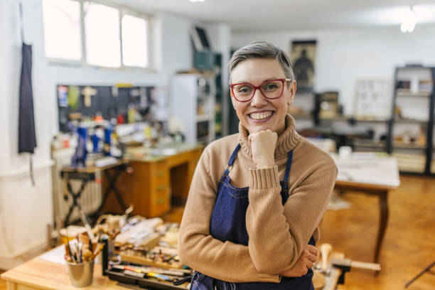 istock Focused jeweller in studio, wearing apron, diverse setup. 2163022896