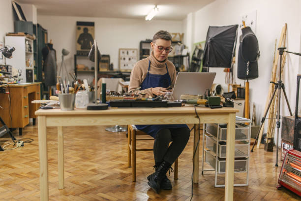 istock Dedicated jeweller engaged in laptop work in a workshop. 2163023476