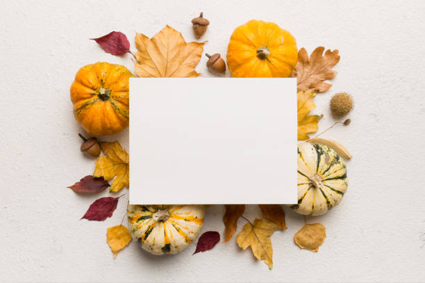 istock Autumn composition with paper blank and dried leaves with pumpkin on table. Flat lay, top view, copy space 2163023532