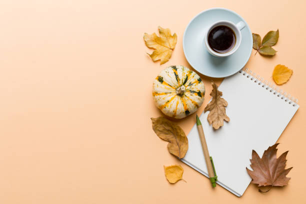 istock Autumn composition: fallen leaves and notebook mock up on colored background. Top view. Flat lay with copy space 2163023545