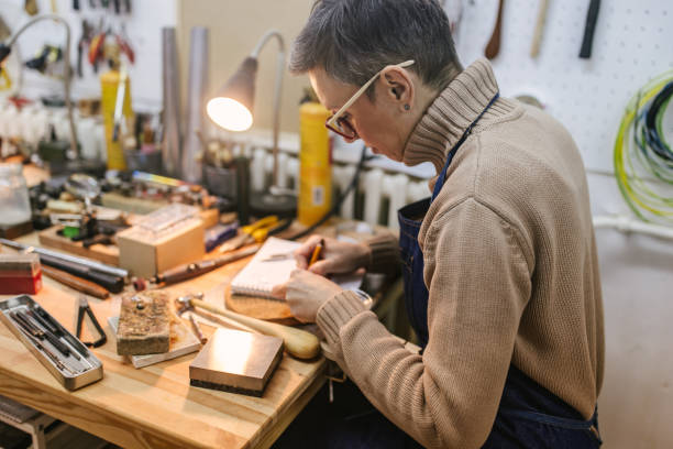 istock Craftswoman engaged in detailed work at organized workbench 2163025089