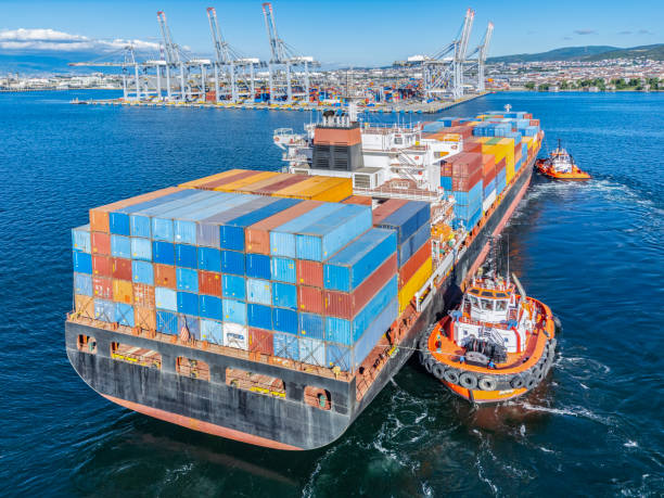istock Aerial view of Cargo Container Ship approaching port with tugboat. 2163027347