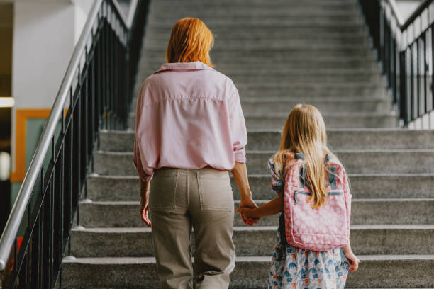 Mother Taking Daughter to School Holding Hands