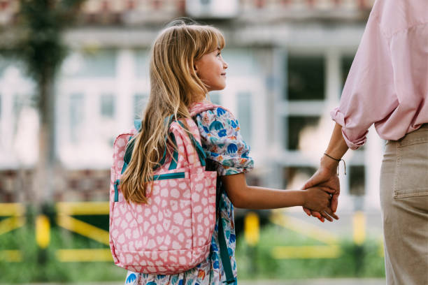 Mother Holding Daughter's Hand on First Day of School