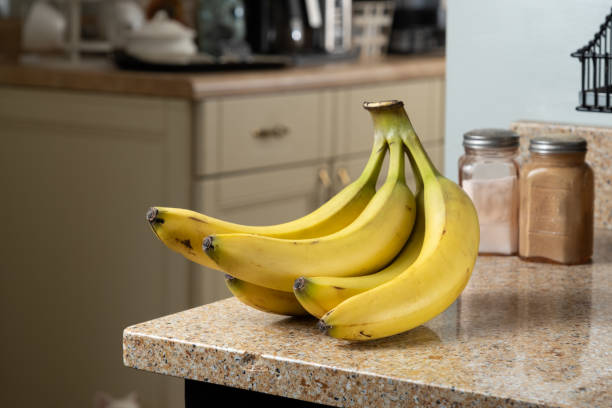 istock Yellow Bananas in a Bunch on Brown Granite Counter 2163033852