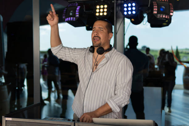 istock Latin DJ playing music at outside party. 2163037310