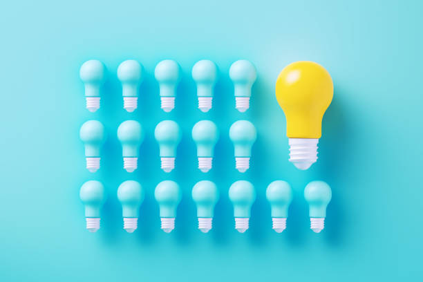 istock Blue And Yellow Light Bulbs On Blue Background 2163039249