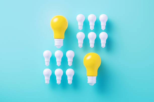 istock Blue And Yellow Light Bulbs On Blue Background 2163039424