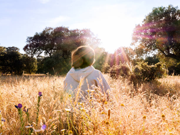 A boy enjoying at the sunset in a tranquil field.