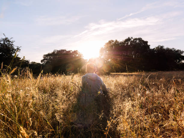 istock Boy Enjoying Sunset in Serene Meadow 2163039906