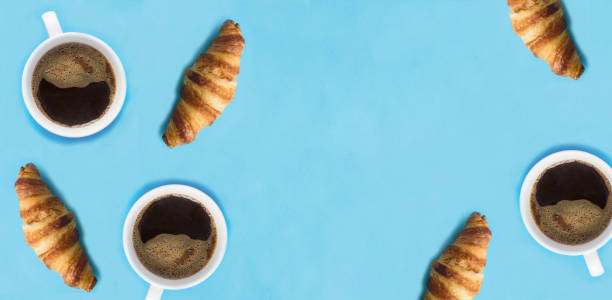 istock Coffee cups and croissants on the blue background. Copy space. Top view. 2163041275
