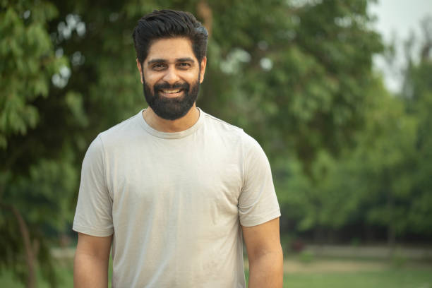 Portrait of confident man standing in park during weekend