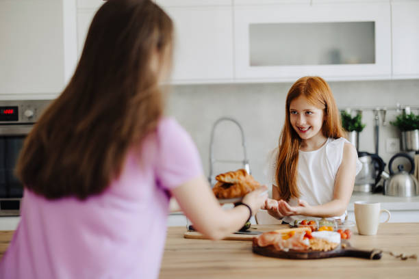 istock Mother with her daughter preparing breakfast at kitchen 2163042484