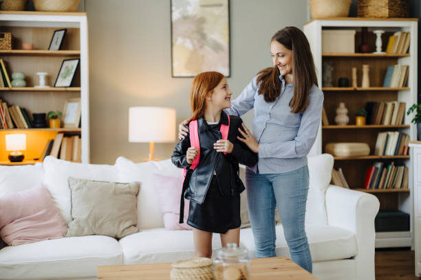 istock Mother Helping Her Cute Daughter Get Ready for School 2163042513