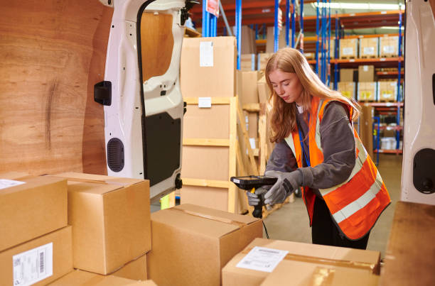 istock warehouse worker scanning delivery items in a van 2163043915