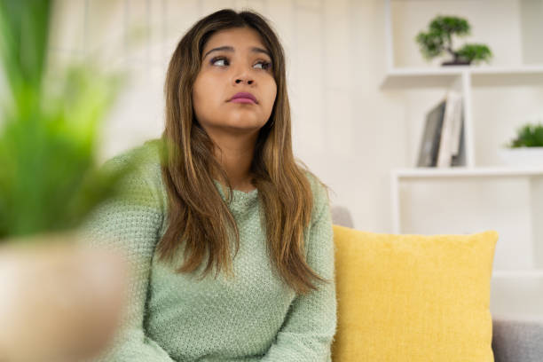 istock Thoughtful and anxious woman sitting on the sofa 2163044585