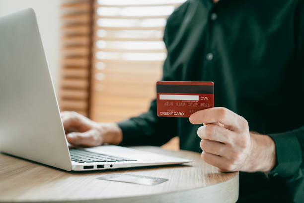 istock Young man using laptop with credit card for internet banking. Unveiling 2163044962