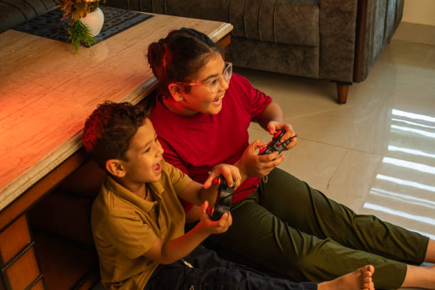 istock Cheerful siblings playing video game at home 2163046192