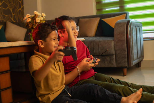 istock Cheerful siblings playing video game at home 2163046359