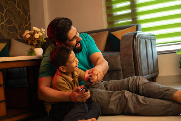 istock Happy young man playing video game with son at home 2163046641