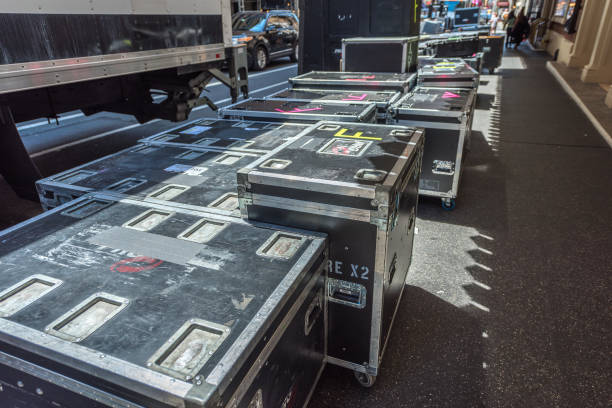 Production team places several professional boxes for musical equipment and costumes at the entrance of a Broadway theater. Professional stage equipment is packed in special boxes.