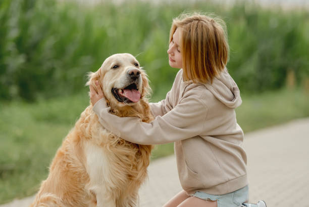 istock Girl Sits With Golden Retriever 2163050103