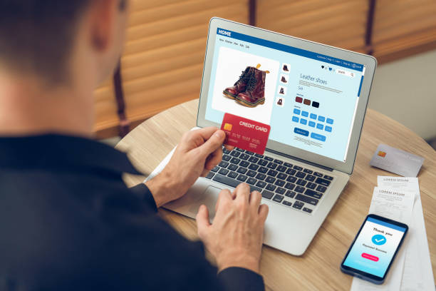 istock Young man using laptop with credit card for internet banking. Unveiling 2163051532