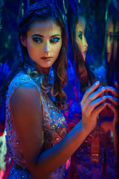 Studio shot of glamorous woman illuminated by blue and red lights