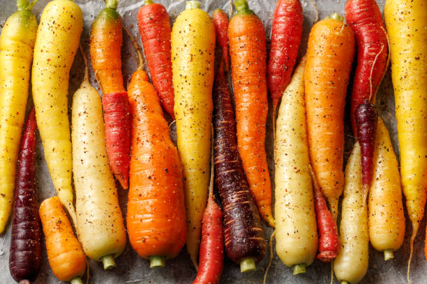 istock Ready to bake rainbow carrots on a parchment lined baking sheet. 2163052550