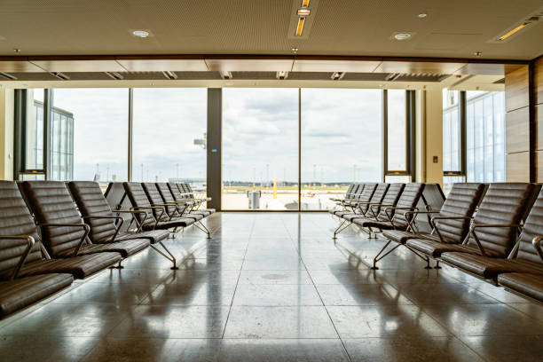 istock Seating area in modern airport terminal with sunlight through large windows 2163056647