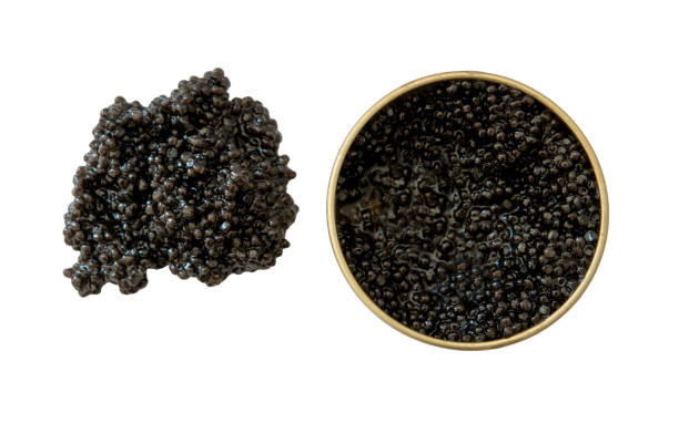 istock Black caviar in and outside an open tin can on white background. 2163056841