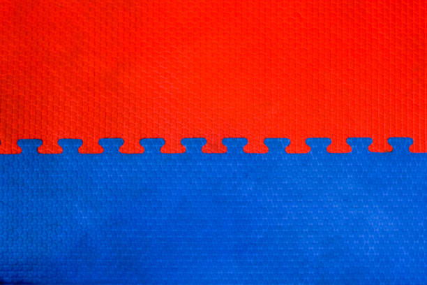 istock Easily interlocking puzzle shaped rubber floor mats to prevent falling shock hazards are widely used in gyms and children's rooms to prevent potential hazards. The background is a blank rubber bumper. 2163056883