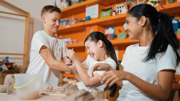 istock Student playing with friend while put the clay on shirt at class. Edification. 2163057101