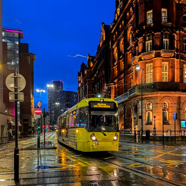 Evening view along a street in the centre of Manchester, UK.  people can be seen on the promenade.