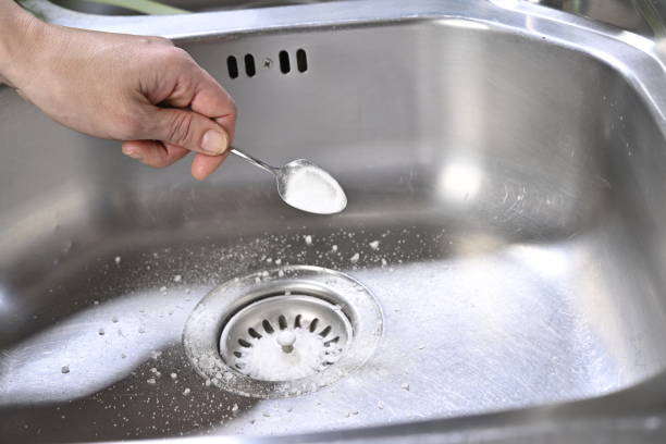 istock Lifehacks; Cleaning kitchen sink with baking soda to keep sinks draining well and prevent clogs 2163059040