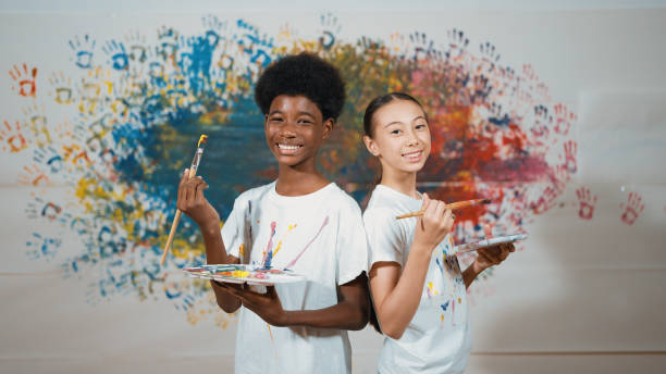 istock Student standing back to back and looking at camera at art lesson. Edification. 2163059121