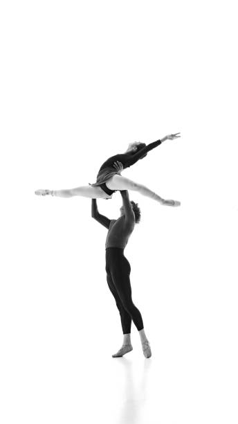 istock Dynamic duo in ballet training, focused on every move against white studio background. Black and white filter. 2163060447