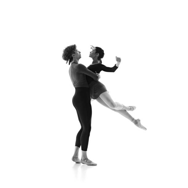 istock Duo's elegant ballet training session. Focused and poised dancers in motion against white studio background. Black and white filter. 2163060451