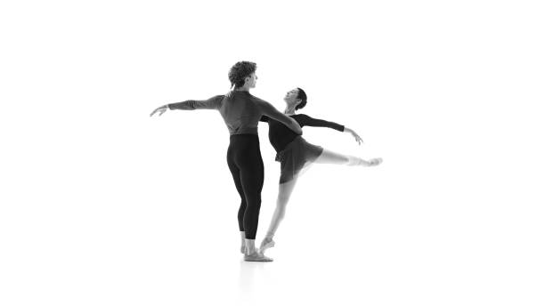 istock Ballet partners training their movements in practice against white studio background. Black and white filter. 2163060458
